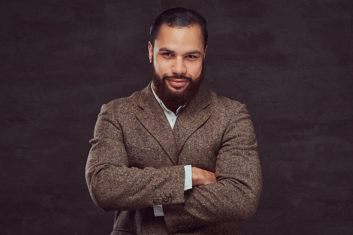 confident-african-american-businessman-brown-classic-jacket-with-crossing-arms-isolated-dark-background_613910-6555